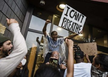 A black child holds a sign "I Can't Beathe"