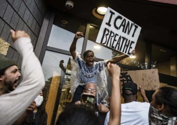 A black child holds a sign "I Can't Beathe"
