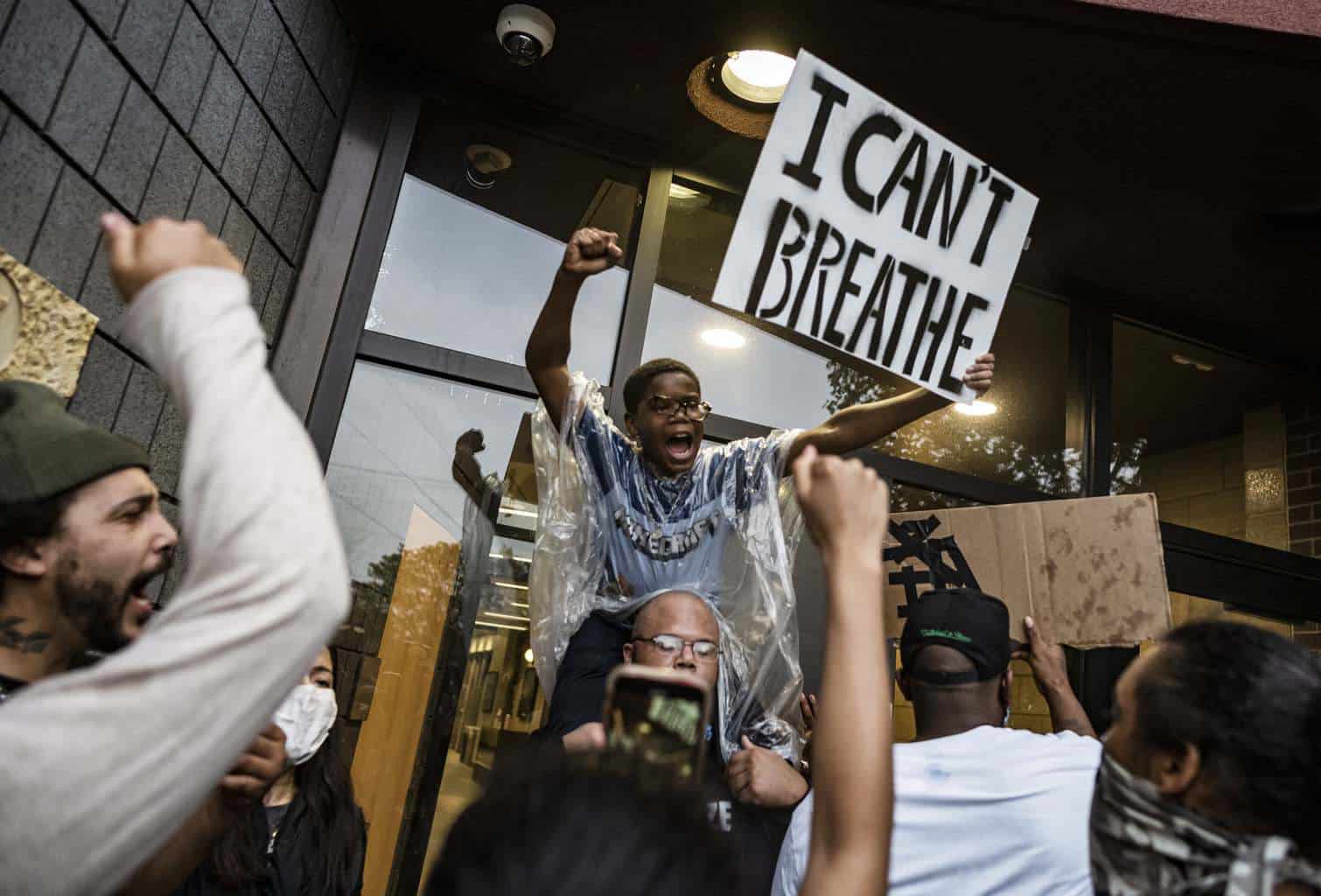 A black child holds a sign "I Can't Beathe"